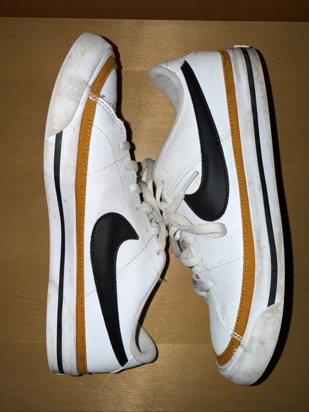 Nike White Low-Top Sneakers with Black Swoosh and Mustard Accent